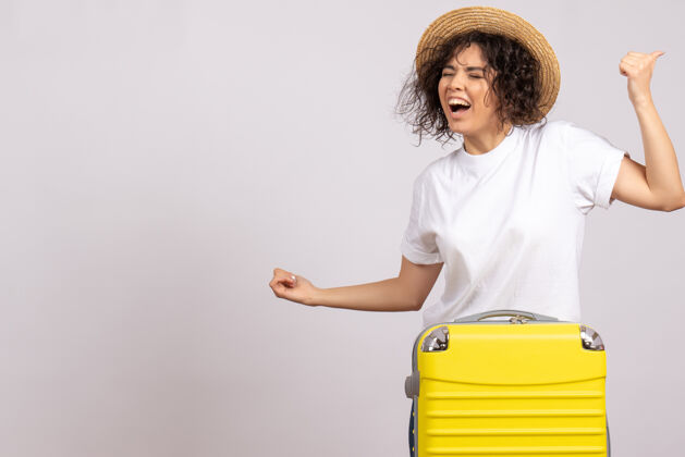 肖像正面图年轻女性带着黄包准备旅行在白色背景上欢庆度假航行彩色飞行旅游飞机休息休息美丽飞行