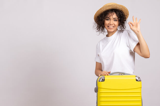 微笑正面图年轻女性带着黄包准备乘坐白色背景色的旅行度假航程旅游飞机休息肖像休息年轻女性