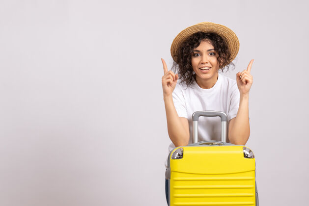 飞行正面图年轻女性带着黄包准备乘坐白色背景的阳光色航程飞机休息旅游航班微笑休息年轻女性