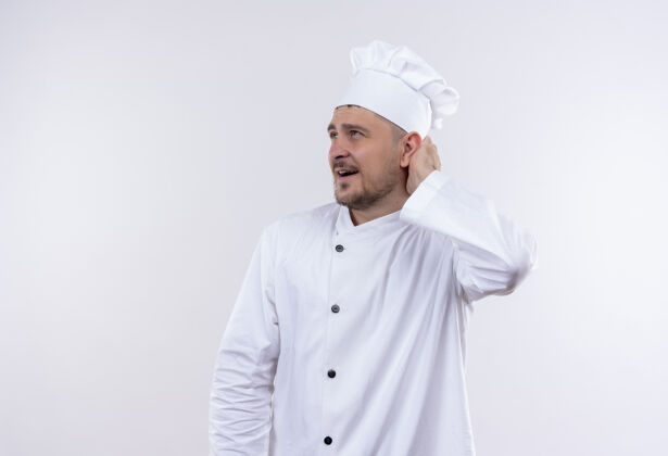 制服年轻帅气的厨师穿着厨师制服 把手放在脑后 看着隔离在白墙上的一边年轻烹饪印象