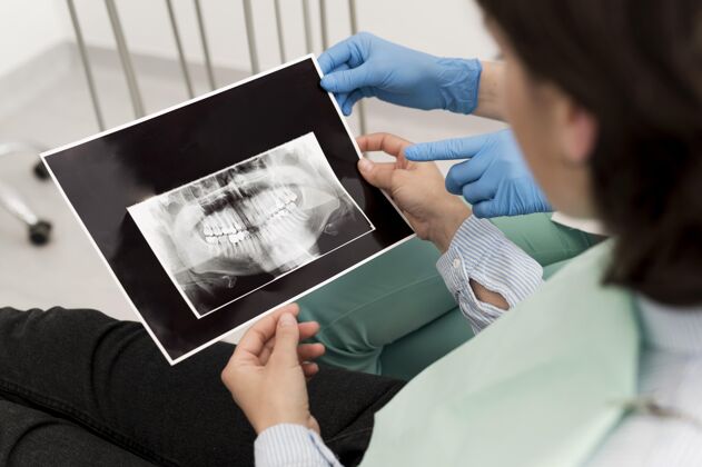 工作女病人和牙医一起看牙齿的X光片水平妇女X光