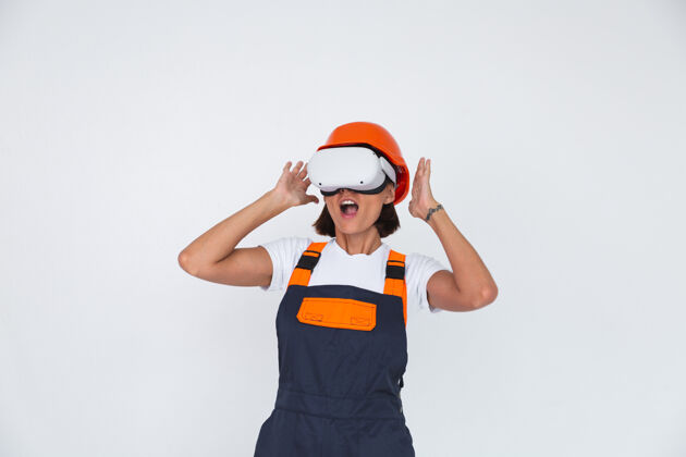 开发漂亮的女工程师在虚拟现实眼镜上戴白色防护头盔机械计算机技师