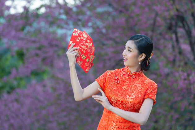 东方美丽的亚洲女人在中国的新年里展示一些东西和拿红包空白展示中国