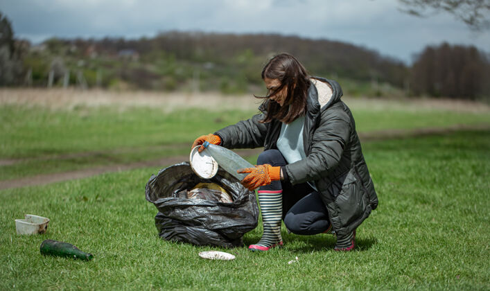 环境女孩志愿者在森林里收集垃圾 保护环境袋子社会垃圾