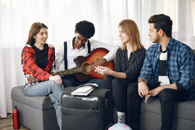 友谊一群形形色色的朋友聚在家里一个人一边弹吉他一边唱歌笑歌曲音乐