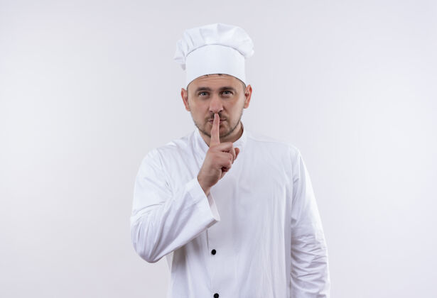 自信自信的年轻帅哥厨师身着厨师制服 在白色的墙壁上用复制空间表示沉默年轻制服姿态