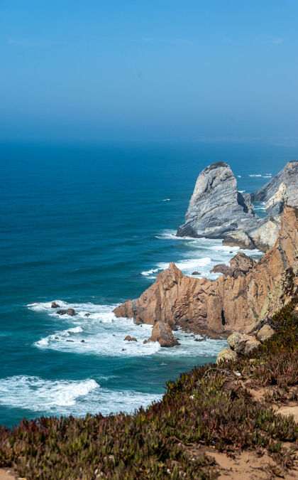 自然海岸上有悬崖和岩石的海洋的垂直镜头水海岸线岩石