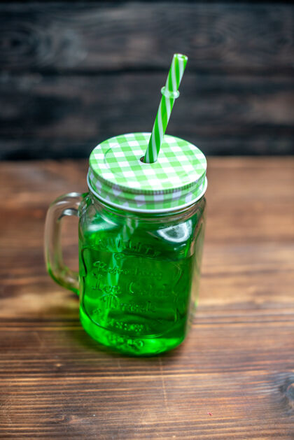 鸡尾酒正面看绿色苹果汁里面可以在棕色的木桌上喝鸡尾酒颜色的水果刷新健康食品