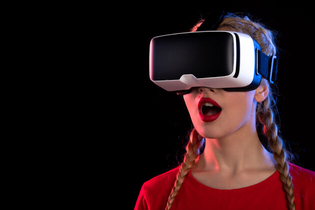 女士年轻女性兴奋地在黑暗的墙上玩虚拟现实的画像兴奋现实游戏