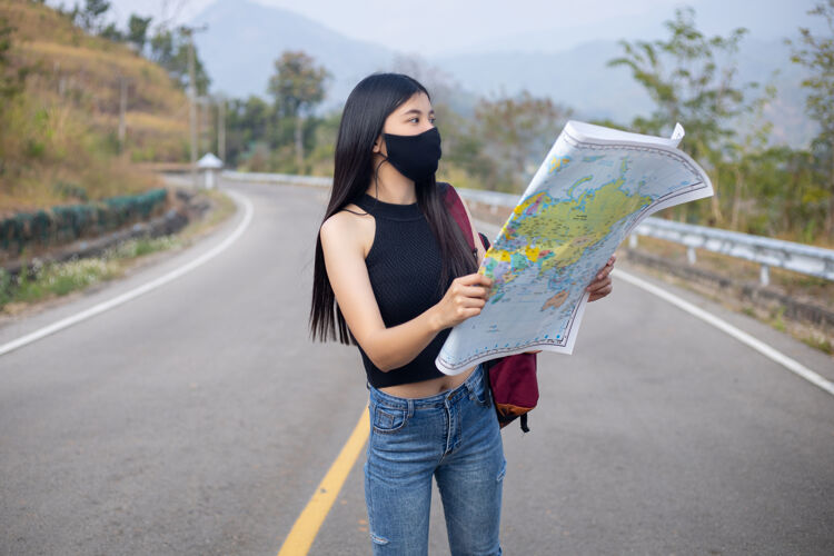预防旅游女孩在地图上寻找正确的方向游客外科口罩女人