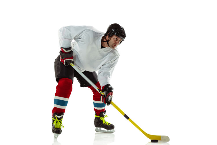 运动员年轻的冰球男选手 冰球场上的棍子和白墙人活动头盔
