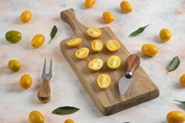 酸一堆金橘 全切或半切在木砧板上异国情调饮食成熟