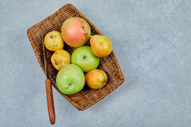 苹果用刀把苹果和梨放在篮子里成熟水果梨