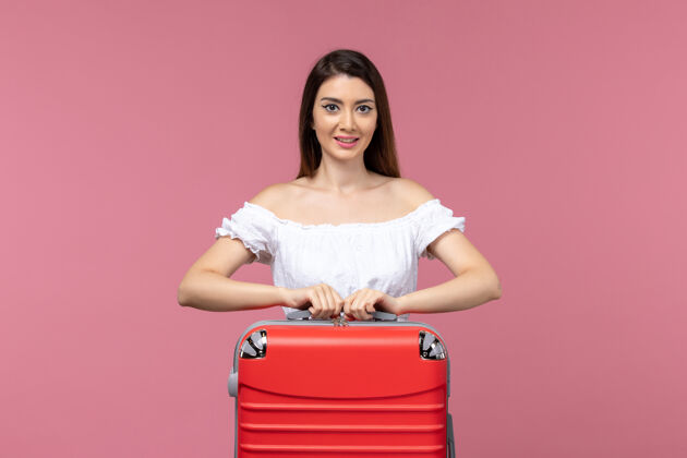头发正面图年轻女子站在粉红色的背景上准备度假海上之旅女子出国度假成人站立准备