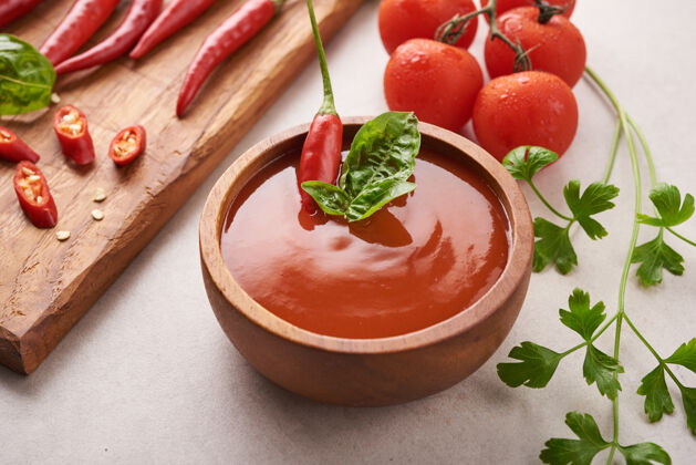 素食者红辣椒酱 番茄酱 辣椒酱 辣椒泥 番茄和大蒜放在石头表面的木砧板上顶视图辛辣番茄美味