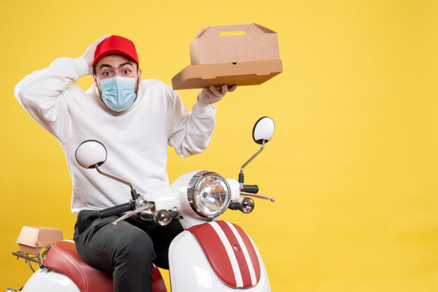 盒子戴着面具的男信使骑在自行车上拿着黄色的食品盒面具男信使车辆