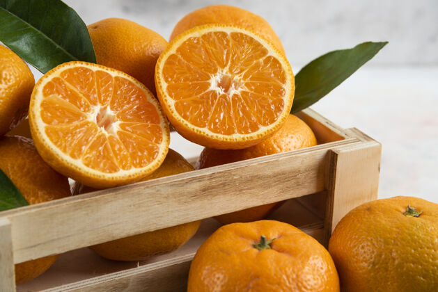 美味新鲜多汁的木盒克莱门汀全切或半切有机食物柑橘