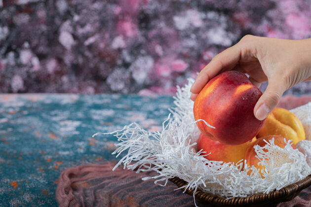 新鲜黄红色的桃子放在白色粗麻布的木篮上蔬菜收获毛巾