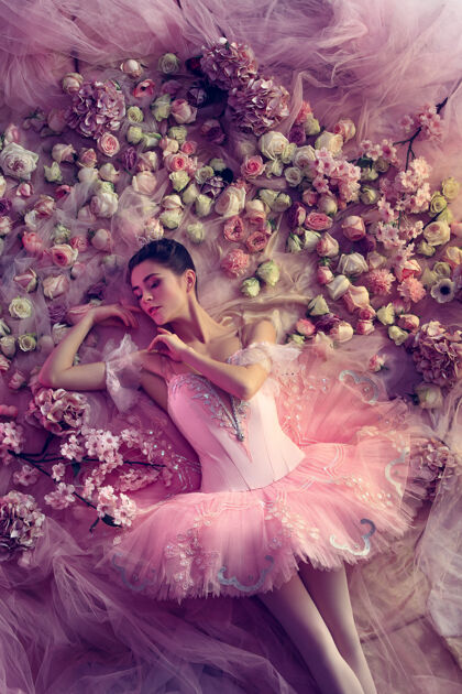 芭蕾舞俯瞰美丽的年轻女子在粉红色芭蕾舞团图图周围的鲜花情绪美丽表演