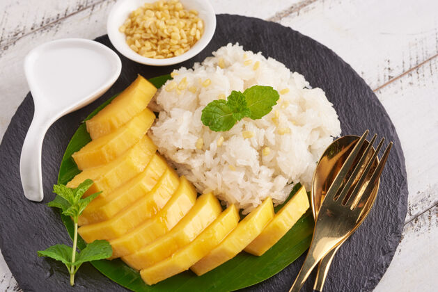 盘子熟透的芒果和糯米加椰奶在石头表面 泰国甜点在夏天的季节牛奶芒果晚餐