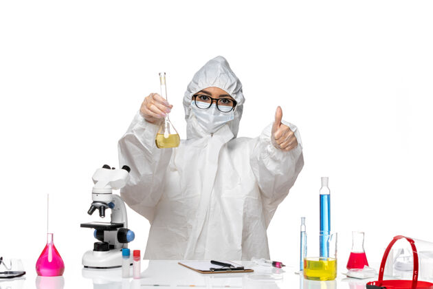 医疗正面图身穿特殊防护服的年轻女化学家拿着烧瓶 背景是白色的实验室冠状病毒-化学病毒医生专业外套