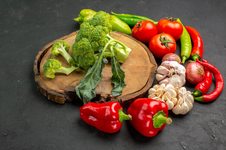 饮食前视图新鲜绿色西兰花与新鲜蔬菜在黑暗的背景生蔬菜胡椒西红柿