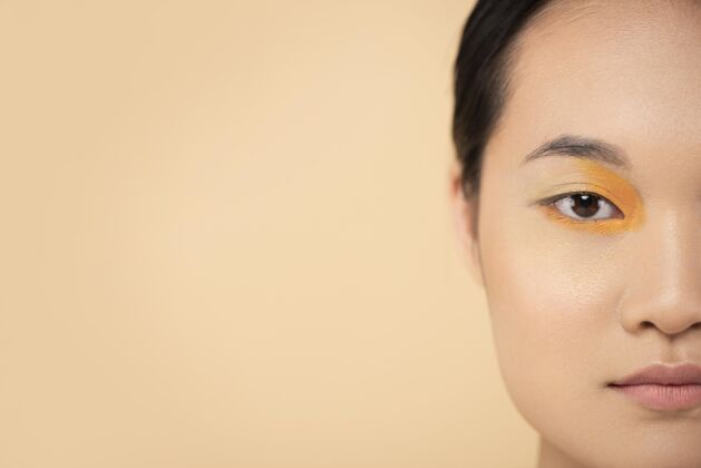 美丽美丽的亚洲女人戴着橙色眼影化妆漂亮随意