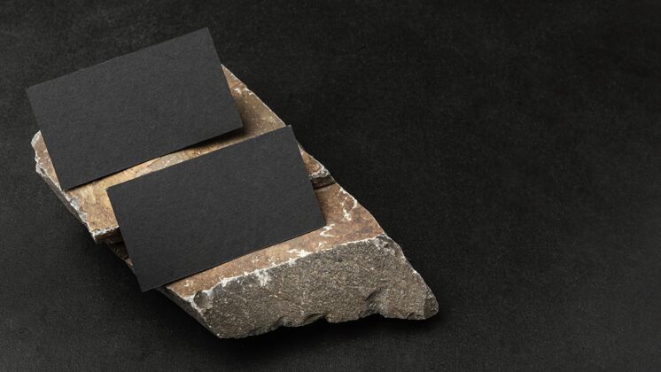文具文具模型在黑暗的混凝土与崎岖的岩石名片水平深色