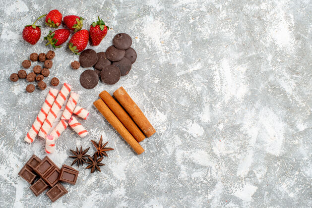 左边顶视图草莓巧克力糖果谷类食品肉桂茴香种子在灰白色桌子的左侧有自由空间八角壁板顶部
