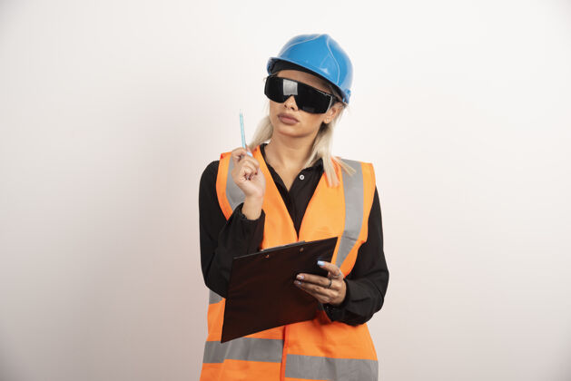 剪贴板带护目镜和剪贴板的女建筑工人高质量的照片护目镜女性人类