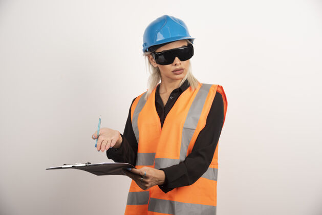 头盔带护目镜和剪贴板的女建筑工人高质量的照片剪贴板建筑工人人