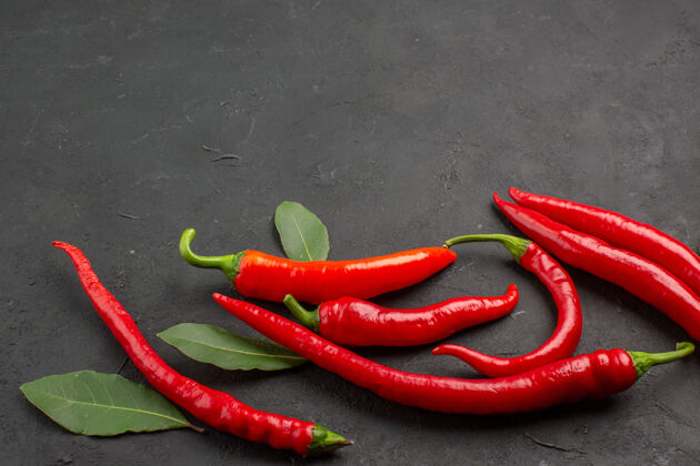 蔬菜底图红辣椒和付叶底部的黑色背景烹饪辣胡椒