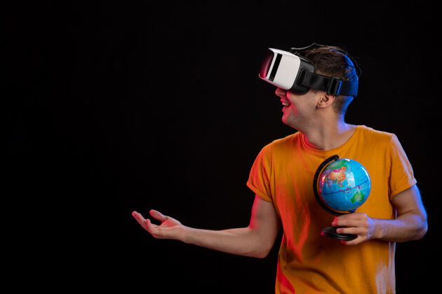 黑在黑暗的表面上玩虚拟现实拿着地球仪的年轻男性虚拟游戏人