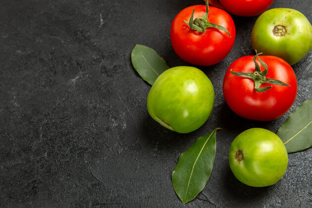健康底图红色和绿色的西红柿和月桂叶在黑暗的背景下吃苹果可食用的水果深色