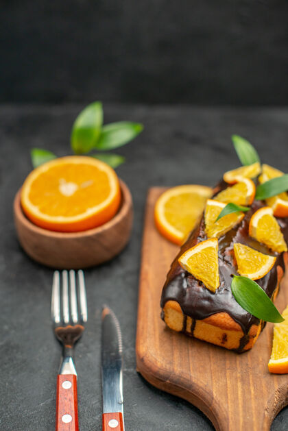 饮食船上的软蛋糕和切柠檬叶在黑暗的背景垂直视图木板新鲜健康