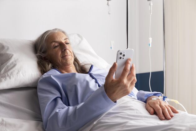 护理生病的女病人躺在医院的床上医疗电话健康