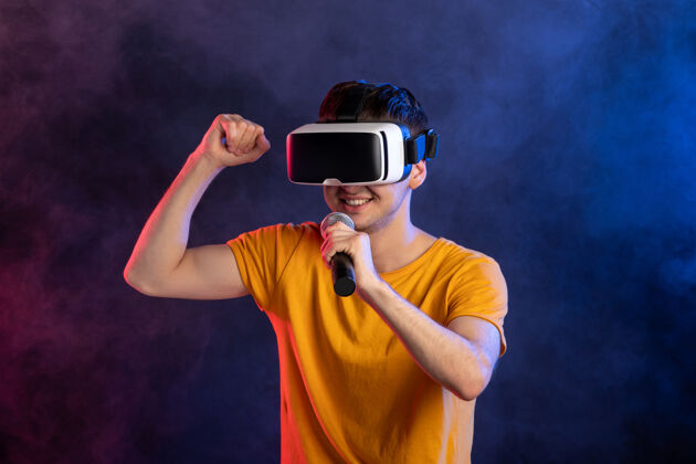 肖像年轻人戴着虚拟现实耳机 唱着深蓝的表面耳机玩家虚拟