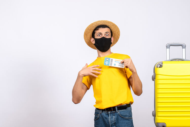 人正面图：穿着黄色t恤的年轻人站在黄色手提箱旁 手里拿着旅行票站立成人T恤