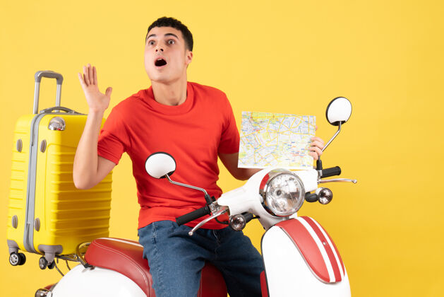休闲正面图：一个穿着休闲服的年轻人拿着旅游地图坐在轻便摩托车上轻便摩托车前面男孩