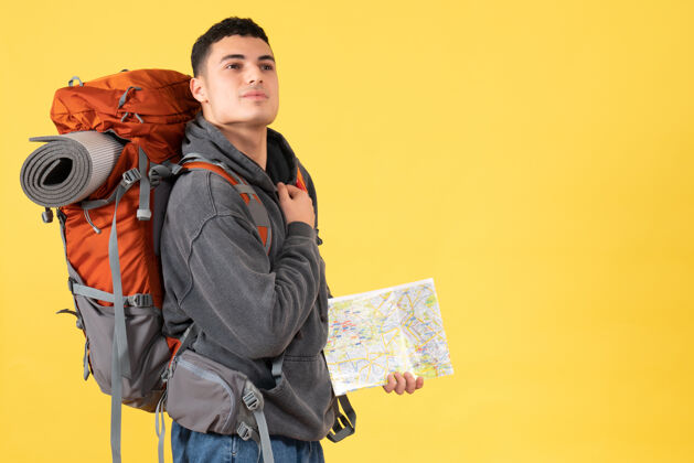 男前视图旅行者男子背着背包拿着地图把手放在胸前前面背包工作