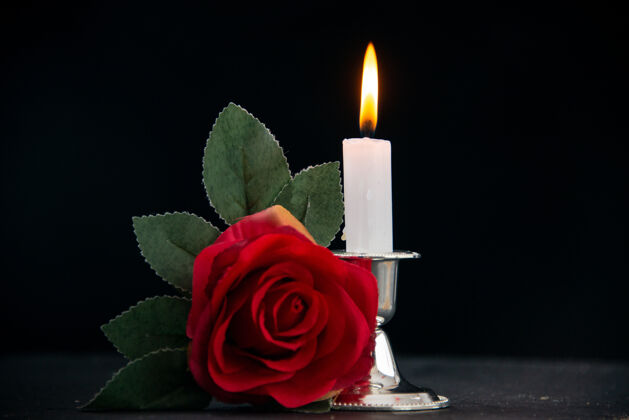 记忆在黑暗的表面上燃烧着红色花朵的蜡烛作为记忆葬礼死亡蜡烛