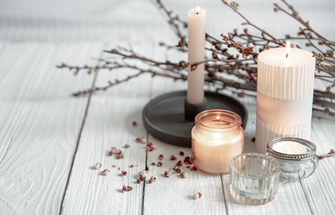 蜡烛在斯堪的纳维亚风格的木制表面上 燃烧的蜡烛和年轻的树枝构成了一个舒适的构图石头茎漂浮