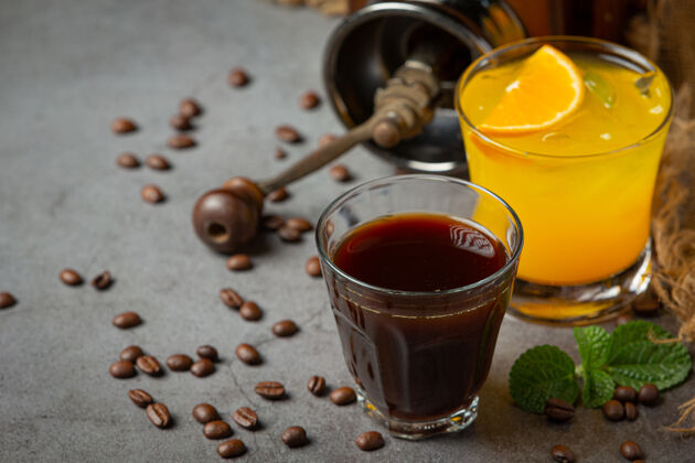 浅橘子和咖啡鸡尾酒在黑暗的表面上冰热带液体