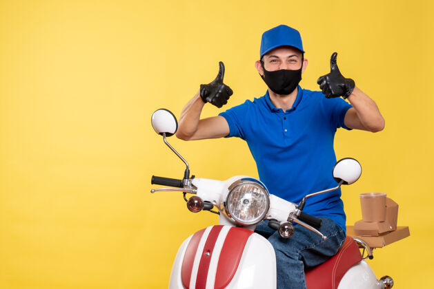 摩托车正面图：身穿蓝色制服 戴着黄色背景面具的年轻男性信使男性年轻男性信使病毒