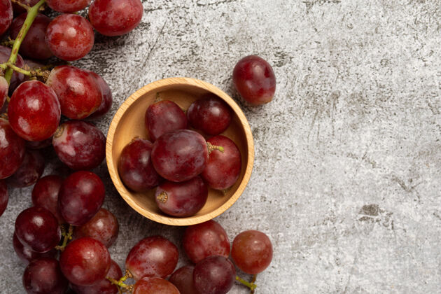 葡萄酒一串串新鲜成熟的红葡萄放在黑暗的表面上组成捆绑大