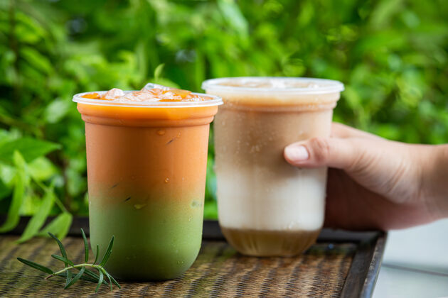 卡路里泰国冰茶与绿茶混合在木制表面立方体咖啡馆食物