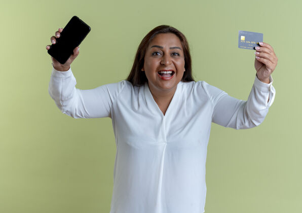 橄榄快乐休闲的白种中年妇女用信用卡举起电话休闲白种人背景