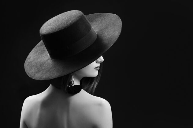 浪漫戴着帽子在黑色背景上摆姿势的漂亮女人隐藏女人诱惑