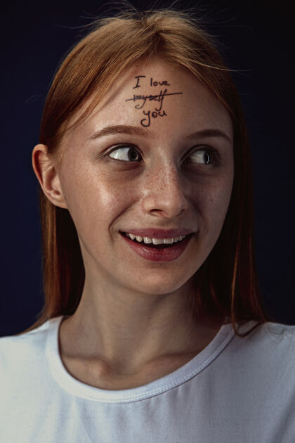 护理年轻女子克服心理健康问题的肖像在额头上纹上“我爱我自己”和“你”不快乐肖像女人