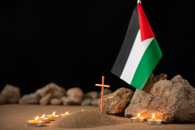 旗在小坟墓周围点着巴勒斯坦国旗的蜡烛燃烧黑暗坟墓